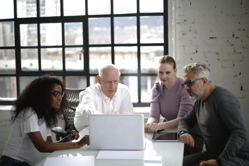 Man In White Long Sleeved Shirt Presenting on a Laptop Free Stock Photo