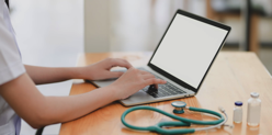 Laptop Near Teal Stethoscope In Wooden Table Free Stock Photo