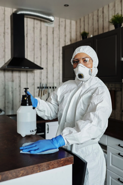 Woman wearing medical protective suit cleaning.