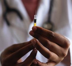 Vaccine in syringe held by nurse.