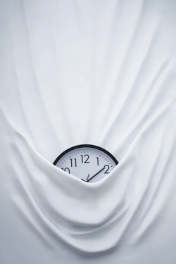 Clock covered up by a white sheet.